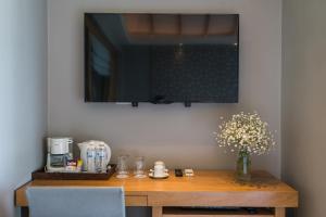 a table with a vase of flowers and a television at KC Grande Resort Koh Chang in Ko Chang