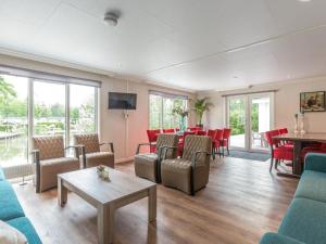 een woonkamer met banken en een eetkamer bij Beautiful house with sandy beach near Giethoorn in De Bult