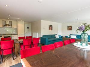 een woonkamer met een tafel en rode stoelen bij Beautiful house with sandy beach near Giethoorn in De Bult