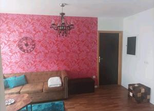 ein Wohnzimmer mit einem Sofa und einer rosa Wand in der Unterkunft Ferien in der Eifel in Berg
