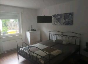 Schlafzimmer mit einem Bett und einem Fenster in der Unterkunft Ferien in der Eifel in Berg