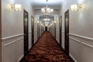 a hallway with a long corridor with mirrors and a red carpet at MILDOM Express in Almaty