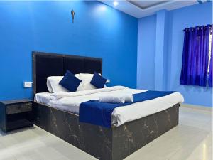 a blue bedroom with a bed with blue walls at Hotel Downtown Calangute in Calangute