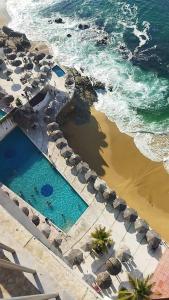 een uitzicht over een zwembad naast de oceaan bij Hermosa Suite en Acapulco in Acapulco