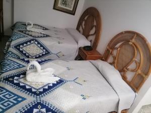 two beds with swans on them in a room at Hermosa Suite en Acapulco in Acapulco