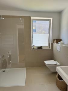 a bathroom with a toilet and a sink and a window at Allerinsel - Appartement am Celler Yachthafen in Celle