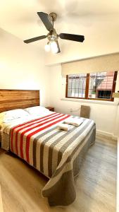 a bedroom with a bed with a ceiling fan at Cálido dpto de 2 ambientes con parrilla y cochera en zona residencial de Punta Mogotes in Mar del Plata