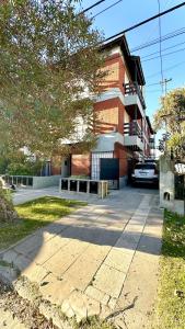 un trottoir devant un bâtiment en briques dans l'établissement Cálido dpto de 2 ambientes con parrilla y cochera en zona residencial de Punta Mogotes, à Mar del Plata