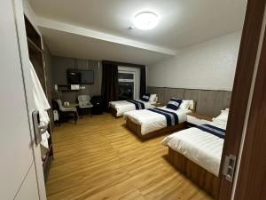 Habitación de hotel con 2 camas y escritorio en Khovuun, en Dalandzadgad