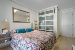 een slaapkamer met een bed met een spiegel en een raam bij Los Gigantes Cliffs Sapphire Ocean View in Puerto de Santiago