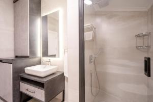 a white bathroom with a sink and a shower at Verula City Suites in Trabzon