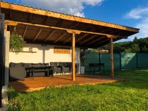 a wooden pergola with a table and chairs under it at Gerana Belchin in Belchin