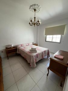 1 dormitorio con 1 cama con mesa y lámpara de araña en Retro Vintage Toscal Bus stop 5p en Los Realejos