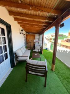 eine Terrasse mit grünem Gras und einem Holzdach in der Unterkunft Retro Vintage Toscal Bus stop 5p in Los Realejos