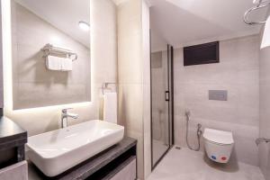 a bathroom with a sink and a toilet and a shower at Verula City Suites in Trabzon