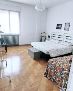 1 dormitorio con 2 camas y suelo de madera en Vista Duomo Ravenna Apartment en Ravenna