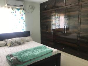 海得拉巴的住宿－2 BHK Apartment at Gachibowli，一间卧室设有大型木制橱柜和一张床