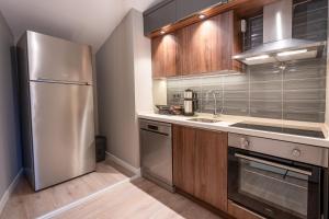 a kitchen with a stainless steel refrigerator and wooden cabinets at Verula City Suites in Trabzon