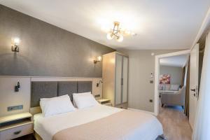 a bedroom with a large white bed and a chair at Verula City Suites in Trabzon