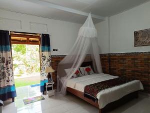 a bedroom with a bed with a mosquito net at Gosela Homestay in Munduk