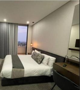 Habitación de hotel con cama y ventana en 11th floor Lux queen room with great balcony view, en Johannesburgo