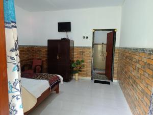 a bedroom with a bed and a mirror in a room at Gosela Homestay in Munduk