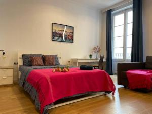 1 dormitorio con 1 cama grande con manta roja en By La Rambla Rooms, en Barcelona