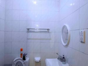 a white bathroom with a toilet and a sink at Olive loft in Dar es Salaam