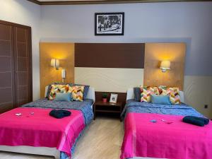 twee bedden in een kamer met roze en blauw bij By La Rambla Rooms in Barcelona