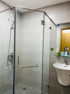 uma casa de banho com uma cabina de duche em vidro e um lavatório. em Livahome - BEE Lux homestay Di An em Dĩ An