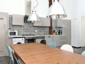 een keuken met een houten tafel en witte apparaten bij Cozy Holiday Home in Olst Wijhe with swimming pool in Olst