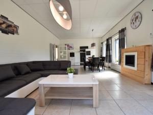 een woonkamer met een bank en een tafel bij Luxury house in South Limburg near forest in Walem