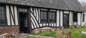 Una casa vieja con rayas blancas y negras. en Golf&Love in Normandy, en Sainte-Opportune-du-Bosc