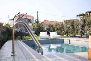a swimming pool with a bench and a chair next to it at Spectacular Epirus Villa | Villa Terra Paradiso | 2 Bedrooms | Private Pool and Terrace | Preveza in Preveza