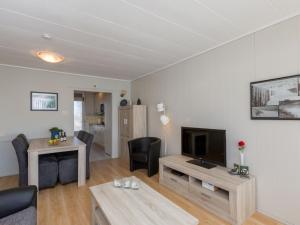 a living room with a television and a table at Attractive apartment near Vlissingen beach in Vlissingen