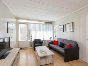 een woonkamer met een bank en een tafel bij Attractive apartment near Vlissingen beach in Vlissingen