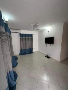 een woonkamer met een flatscreen-tv aan de muur bij 3 bedroom, free Wi-fi, Aircon & Hot water in Tujering
