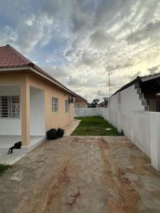 a cat is sitting next to a house at 3 bedroom, free Wi-fi, Aircon & Hot water in Tujering