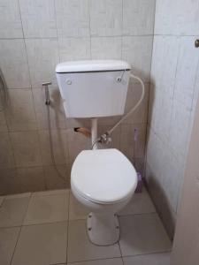 een badkamer met een wit toilet in een stal bij 3 bedroom, free Wi-fi, Aircon & Hot water in Tujering