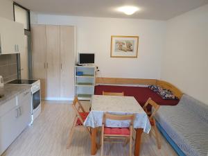a kitchen with a table and chairs in a room at Apartmani Vuković in Gajac
