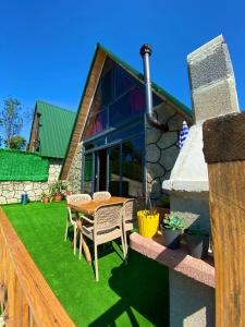 a house with a table and chairs on a lawn at İnziva Bungalow1 in Ardeşen