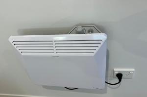 eine weiße Klimaanlage in der Ecke eines Zimmers in der Unterkunft Short Stay- ENTIRE GUESTHOUSE! in Halcombe