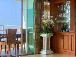 un jarrón de flores en un pilar en un comedor en OceanView Relaxing Suite & Yahaha en Jomtien Beach