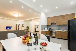 a kitchen and dining room with a table with wine glasses at Premium 2 Bedroom Apartment lll in Tbilisi City