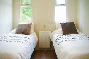 dwa łóżka w pokoju z dwoma oknami w obiekcie Lovely Holiday Home in Kattendijke near Centre w mieście Kattendijke