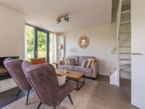 een woonkamer met een bank en een tafel en stoelen bij Beautiful villa with sauna near the sea in Egmond aan den Hoef
