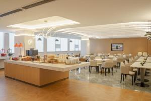 a restaurant with tables and chairs in a room at Atour Hotel Xiamen North Station Jiageng Stadium in Xiamen