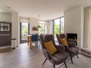 een woonkamer met een tafel en stoelen en een keuken bij Beautiful villa with sauna near the sea in Egmond aan den Hoef