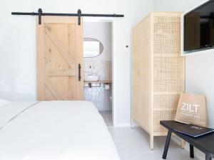 um quarto com uma cama e uma porta de correr no celeiro em Pleasaing holiday home in Oostkapelle near centre em Oostkapelle