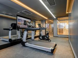 a gym with two tread machines and a flat screen tv at Atour Hotel Xiamen North Station Jiageng Stadium in Xiamen